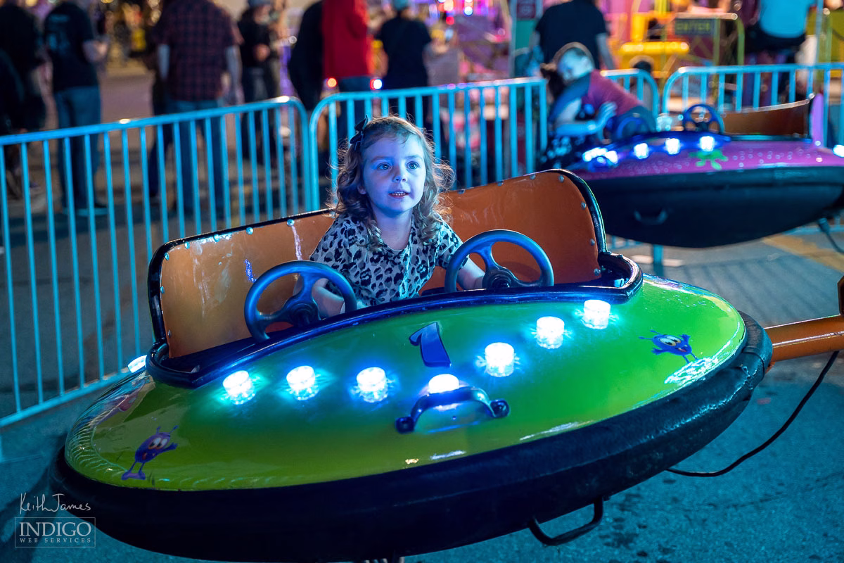 A little girl on a carnival ride at night at Corn School in LaGrange, Indiana.