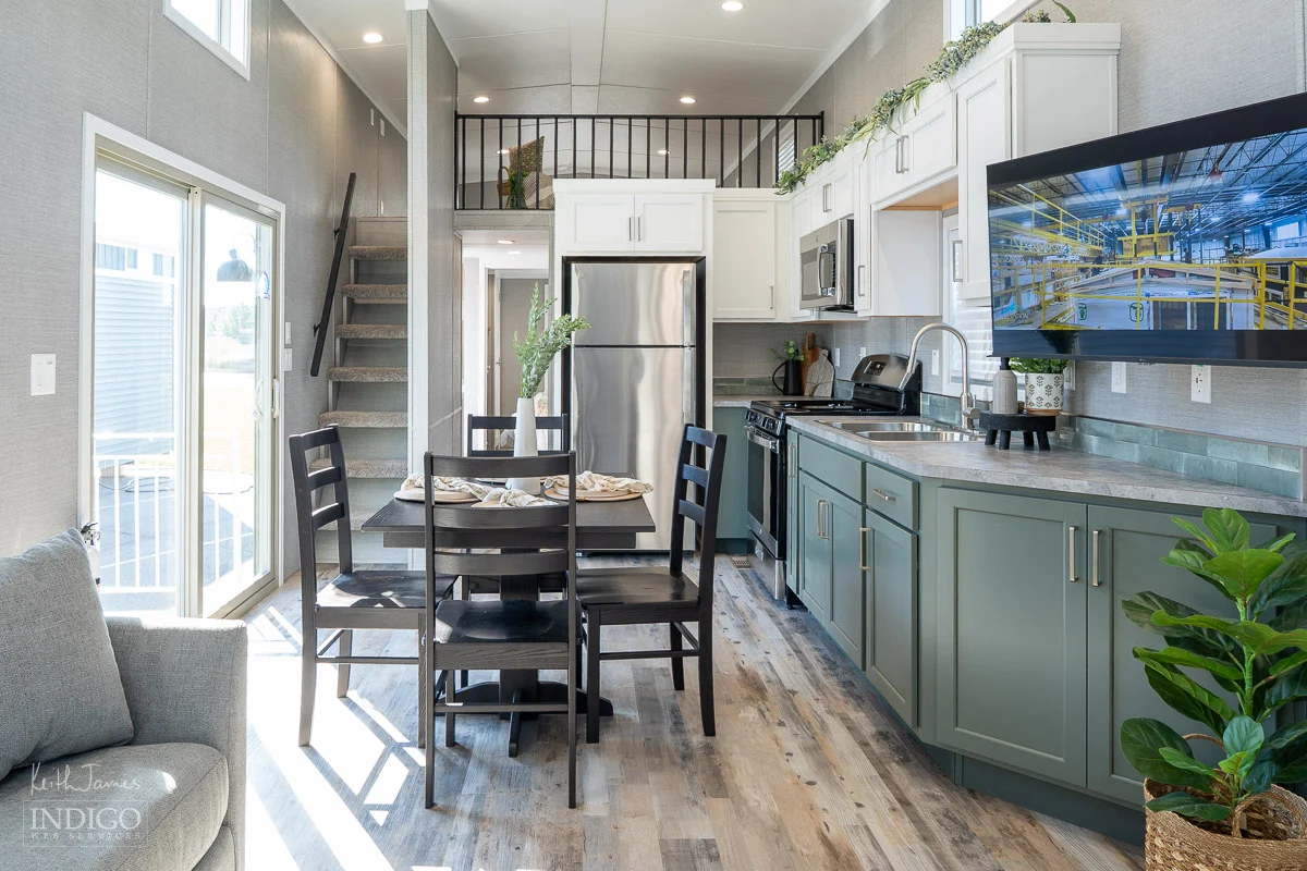 Sales brochure photo of the kitchen and dining area of a park model RV.