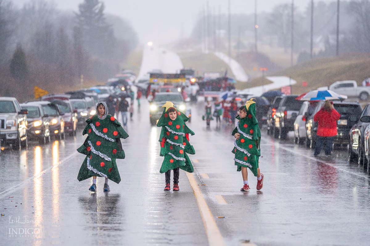 Boys dressed as Christmas trees marching in rain at the annual Santa Claus, Indiana Christmas parade.