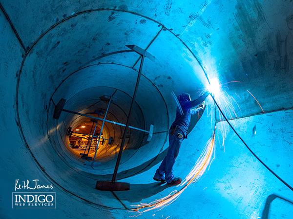 Award-winning photo of a welder in a 10' diameter stainless steel pipe.